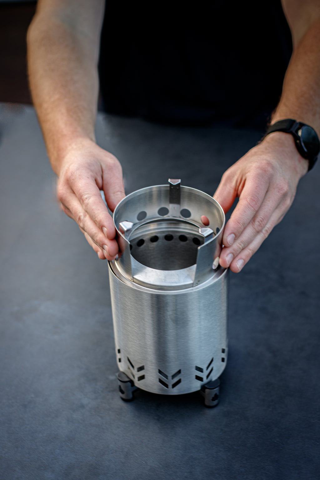Person holding a stainless steel table top fire pit